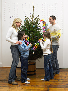 家人在装饰圣诞树图片