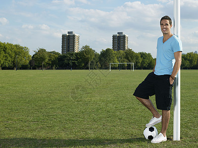 在公园里踢足球的人背景图片