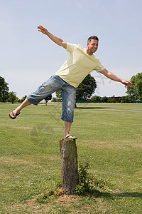 在树桩上保持平衡的人图片