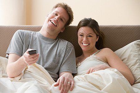 在床上看电视的夫妻图片