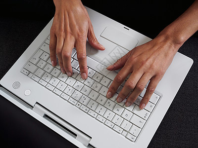 在笔记本电脑上打字的女人背景图片