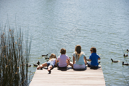 孩子们在湖边喂鸭子背景图片