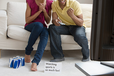 一对夫妇在电视上看体育节目图片