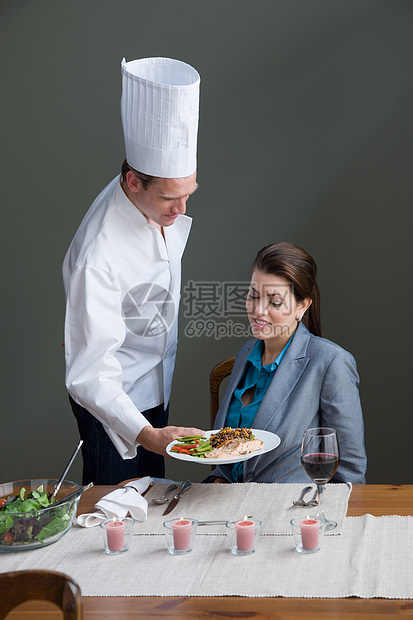 一位主厨为一位女士提供一顿饭图片
