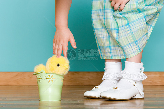 小女孩抚摸着一只柔软的玩具鸡图片
