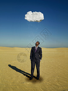 商人站在沙漠的雨云下图片