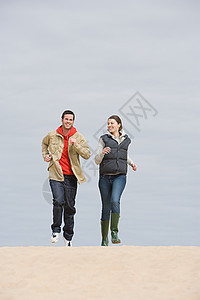 年轻夫妇在海滩上慢跑图片