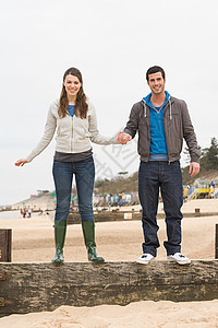 一对夫妇站在海滩的栅栏上图片