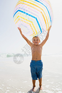 男孩举起一个巨大的沙滩球图片