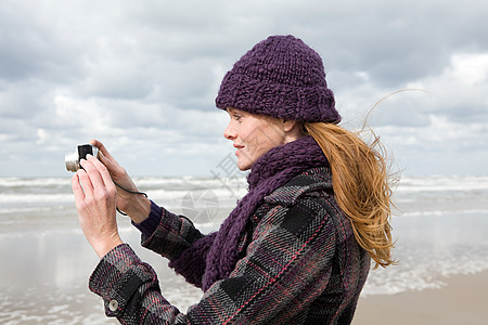海边的女人使用照相机背景图片