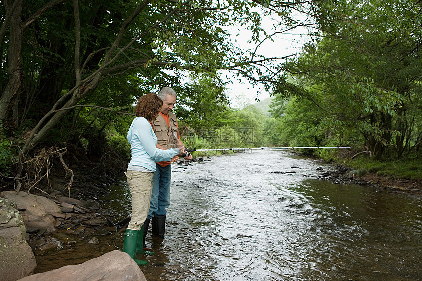 中老年夫妻在溪流中捕鱼图片