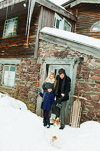 雪中乡村小屋外的家庭图片