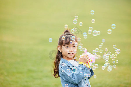 儿童户外小女孩草地上玩泡泡机背景