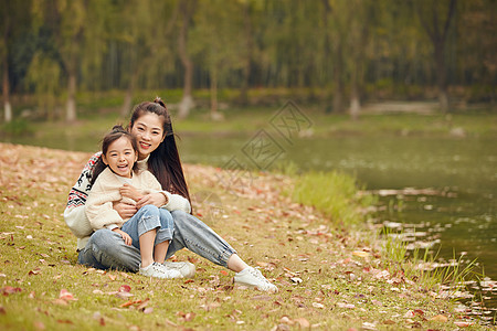 唯美秋叶温馨母女坐在草地上背景