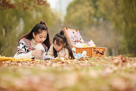 温馨母女趴在草地上看书图片