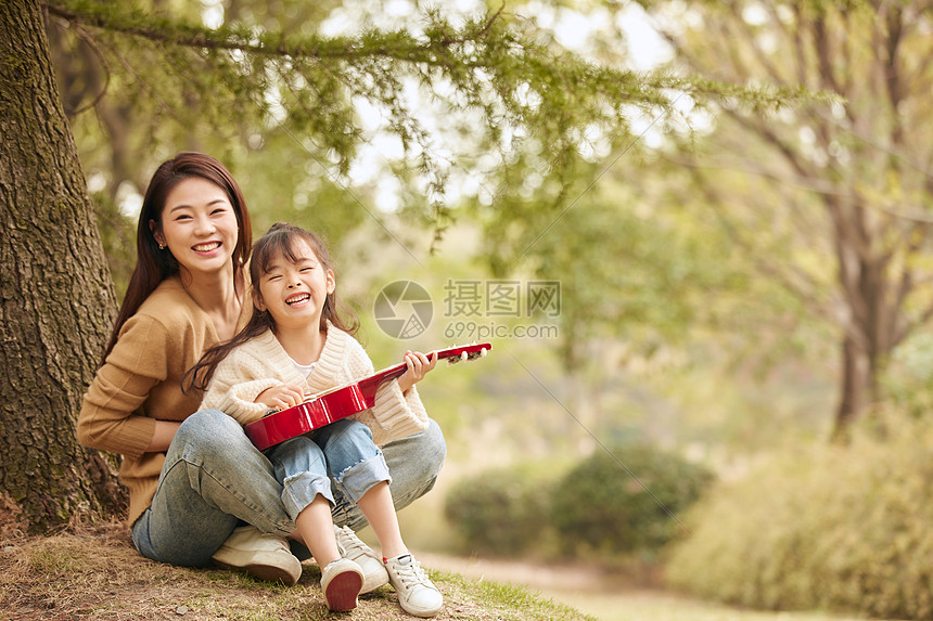 母女坐在树下弹尤克里里图片