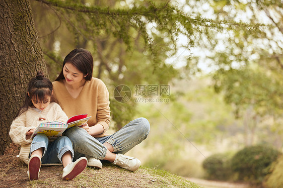 温馨母女坐在树下读书图片