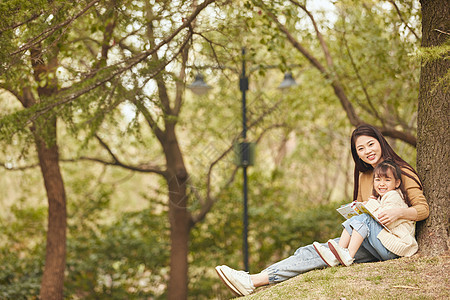 温馨母女坐在树下读书图片