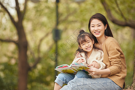 温馨母女坐在树下读书图片