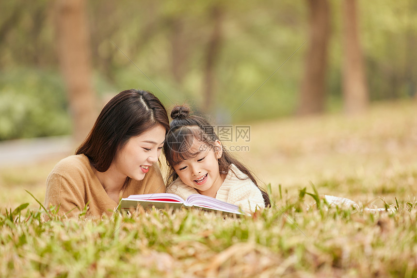 母女趴在草地上读书图片