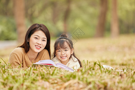 母女趴在草地上读书图片