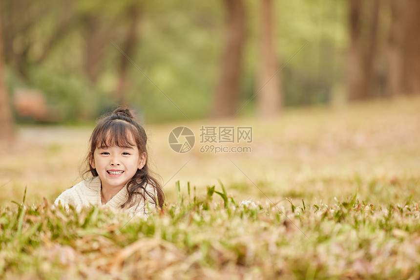 可爱的小女孩趴在草地上图片