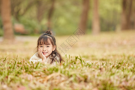 可爱的小女孩趴在草地上图片