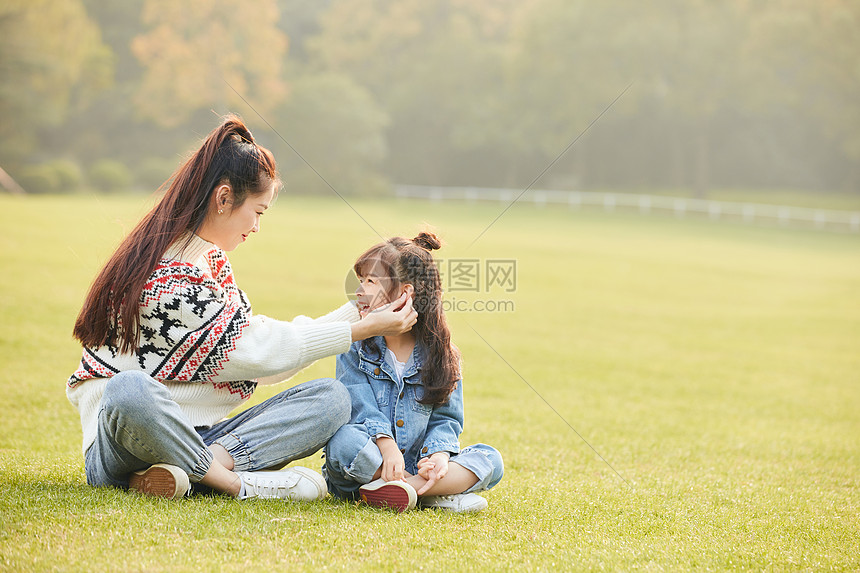 温馨母女坐在草坪玩耍图片