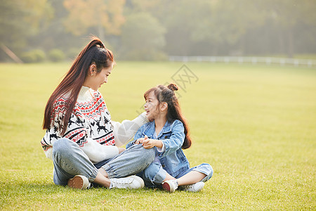 温馨母女坐在草坪玩耍图片
