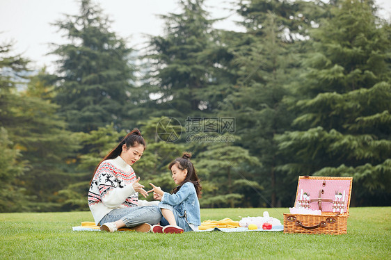 母女坐在草地上玩游戏图片