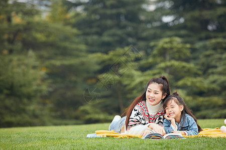 母女趴在草地上阅读图片
