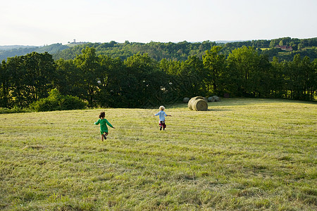 男孩和女孩在草地上奔跑图片