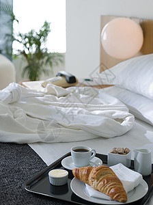 酒店床上的浴袍和早餐图片
