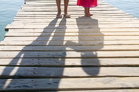码头上儿童和成人的影子图片