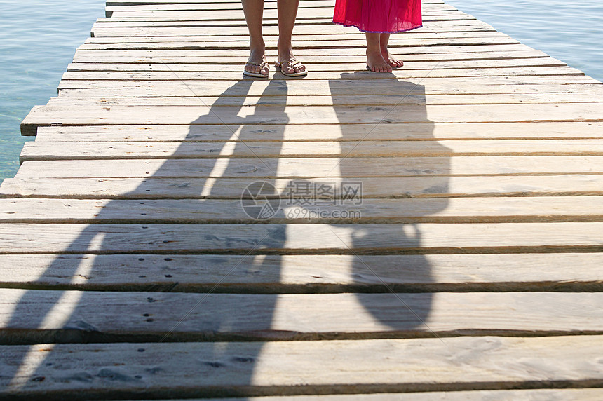 码头上儿童和成人的影子图片