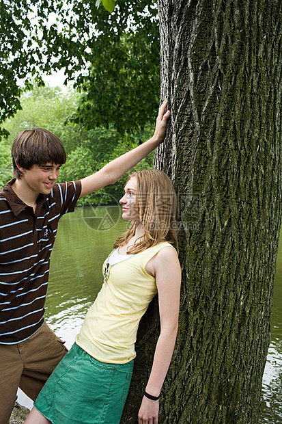 一对年轻夫妇在树旁调情图片