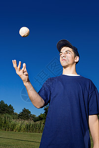 男孩向空中扔棒球图片