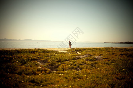 年轻女子独自站在海滩上图片