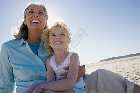 奶奶和孙女坐在海滩上图片
