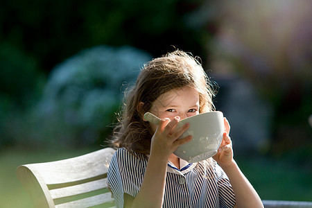 年轻女孩在花园里喝酒图片