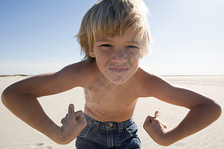 男孩在海滩上伸展肌肉图片