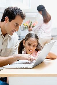 父亲和女儿使用笔记本电脑图片