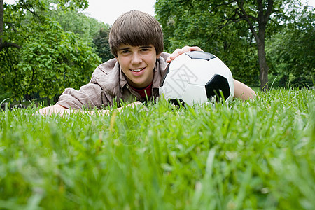 在公园里踢足球的十几岁男孩图片