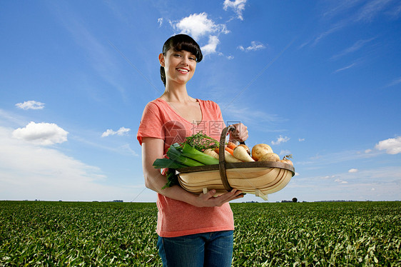 田里的女人拿着一篮国产蔬菜图片