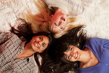 三个年轻女人躺在白地毯上图片