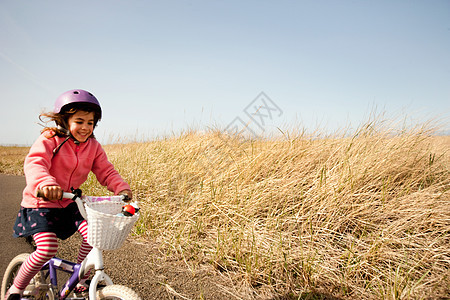 年轻女孩沿着小路骑车图片