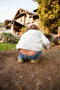 在花园里弯腰的小女孩图片素材