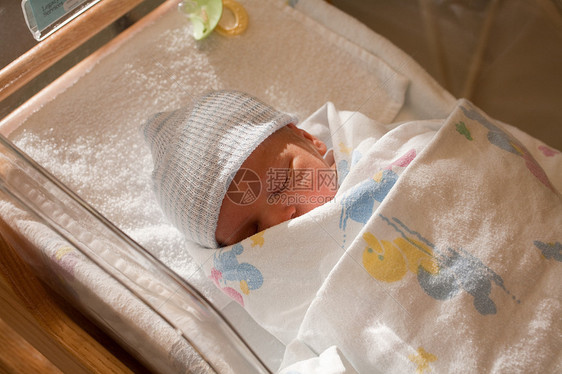 医院婴儿床中的新生男婴图片