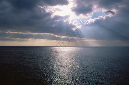 阳光透过云层照射在海面上背景