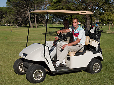 两个中年男性在高尔夫球场的高尔夫球车上图片